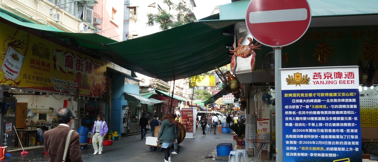 Saigon Street in Jordan running toward Nathan Road, old tenement blocks lining both sides above a vegetarian restaurant and a clinic.