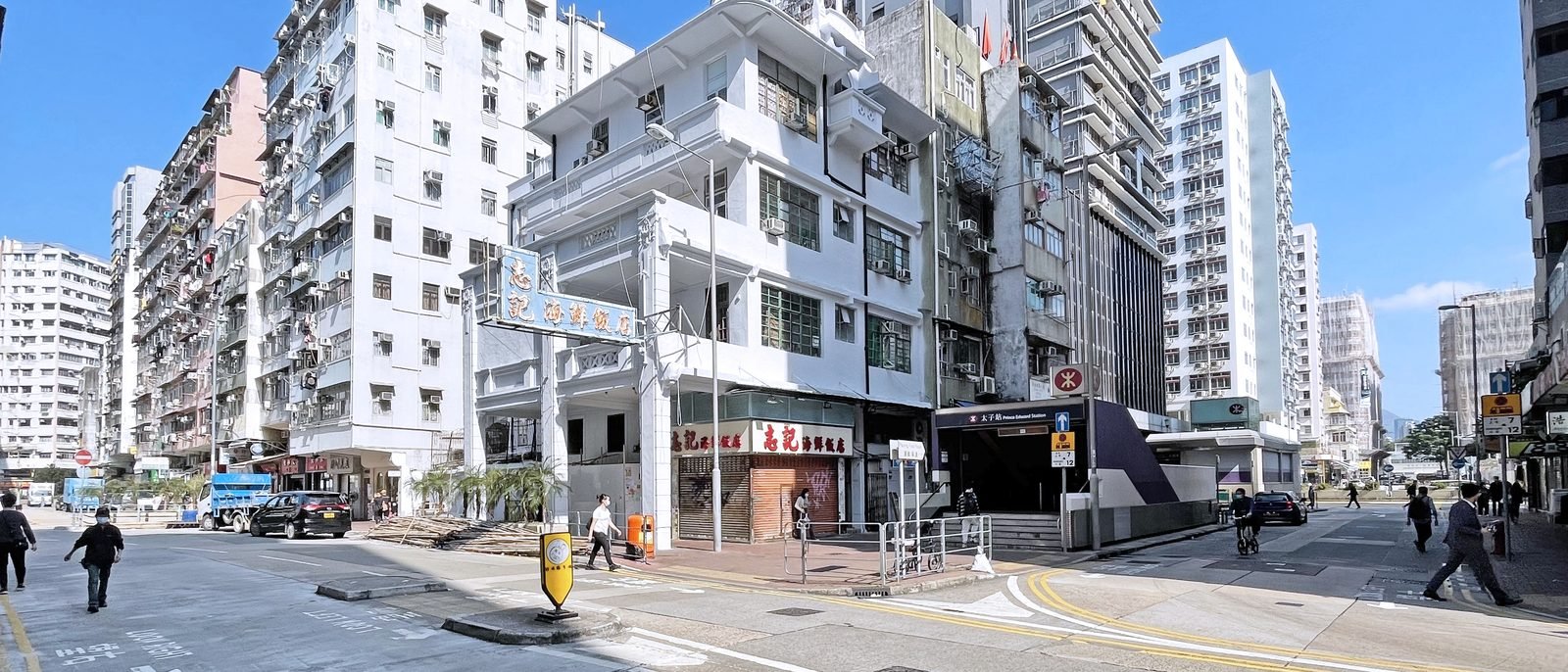 A pre-war corner shophouse beside the Prince Edward MTR station entrance, its ground floor a seafood restaurant.